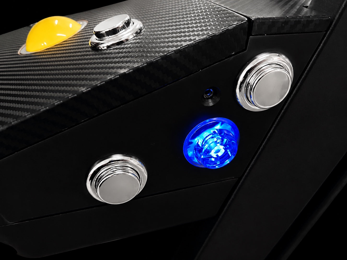 Close-up of the illuminated center flipper button and two chrome side buttons